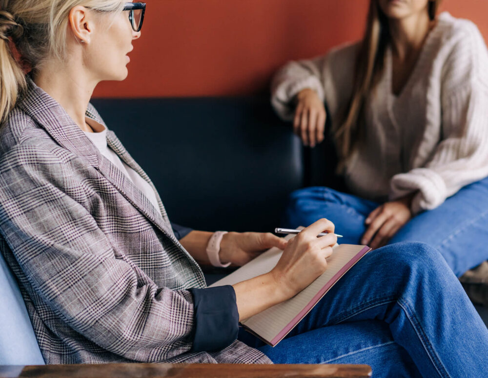 A clinician and patient reviewing diagnostic notes and treatment goals during a psychiatric consultation